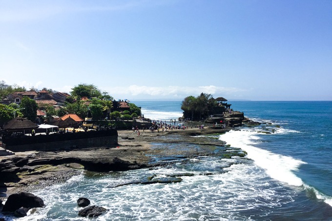 Tanah Lot là ngôi đền được xây dựng trên một khối đá khổng lồ bên bờ biển. Truyền thuyết kể rằng ngôi đền được xây dựng từ năm 1546 bởi một tu sĩ người Ấn Độ đến Bali để truyền bá đạo Hindu. Người dân Bali tin rằng, ngôi đền được bảo vệ bởi những con rắn thần, hàng đêm chúng sẽ bò lên để nhận vật cúng dường. Tanah Lot cũng là một trong những điểm ngắm hoàng hôn đẹp nhất trên đảo Bali. Ảnh: Khương Nha. Tanah Lot là ngôi đền được xây dựng trên một khối đá khổng lồ bên bờ biển. Truyền thuyết kể rằng ngôi đền được xây dựng từ năm 1546 bởi một tu sĩ người Ấn Độ đến Bali để truyền bá đạo Hindu. Người dân Bali tin rằng, ngôi đền được bảo vệ bởi những con rắn thần, hàng đêm chúng sẽ bò lên để nhận vật cúng dường. Tanah Lot cũng là một trong những điểm ngắm hoàng hôn đẹp nhất trên đảo Bali. Ảnh: Khương Nha.