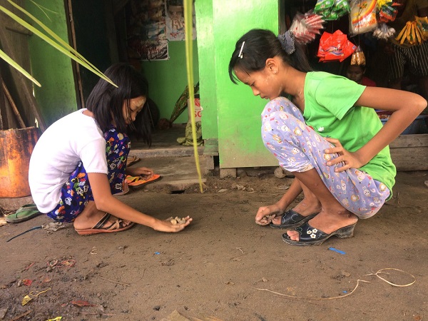 Kế bên người phụ nữ đan vách tre là hai cô bé chơi thảy đá khéo léo - Ảnh: Bông Mai Kế bên người phụ nữ đan vách tre là hai cô bé chơi thảy đá khéo léo - Ảnh: Bông Mai